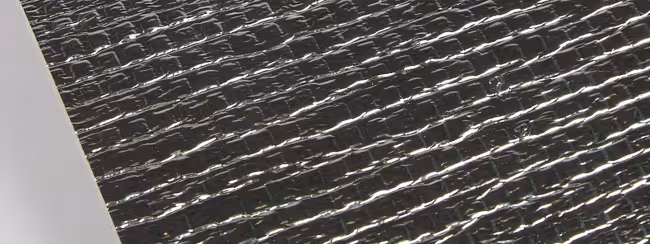 Foglio isolante con superficie argentata e texture increspata.